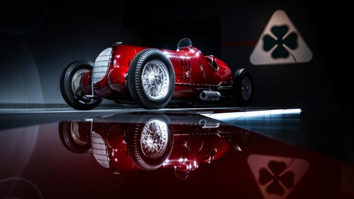 A red race car sitting on top of a reflective surface